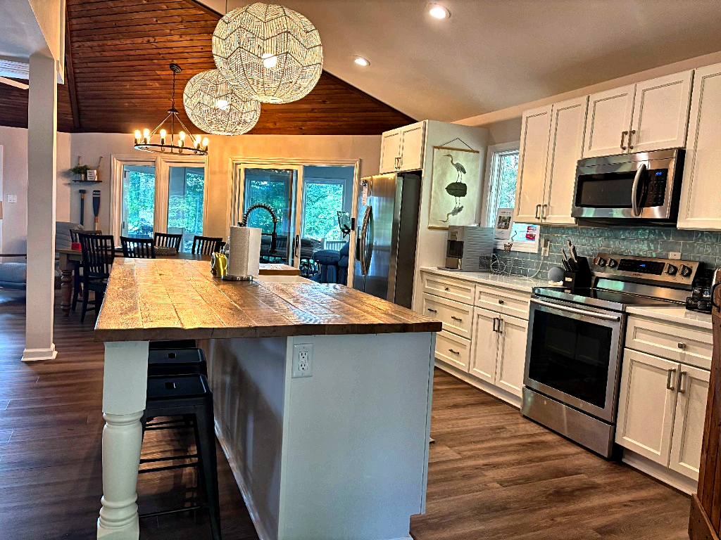 Kitchen with wood island, pendant lights, and stainless appliances