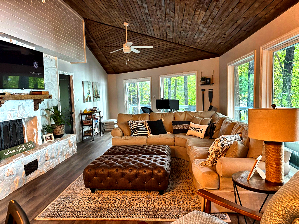 Main floor living room with stone fireplace and lake views